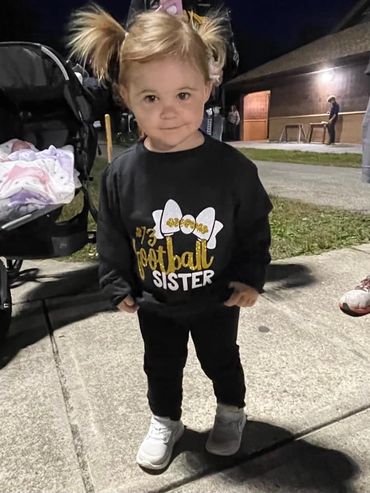 Our first apparel model Adrianna, supporting her brother with her glitter sweatshirt.