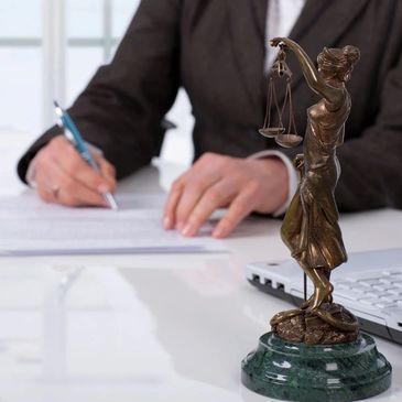 Lady justice statue overlooking a document signing.