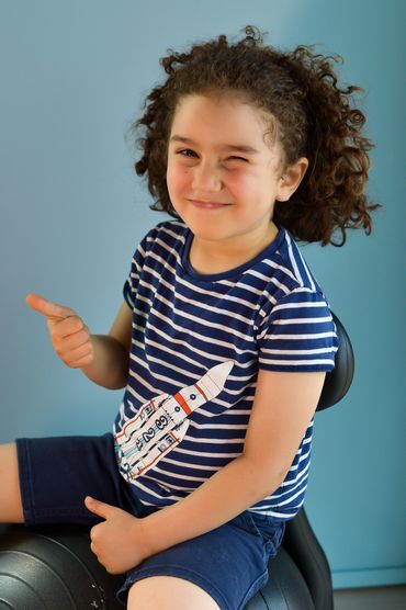 Child's portrait on light blue window shade background