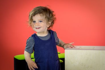 Toddler portrait on red paper backdrop.  
