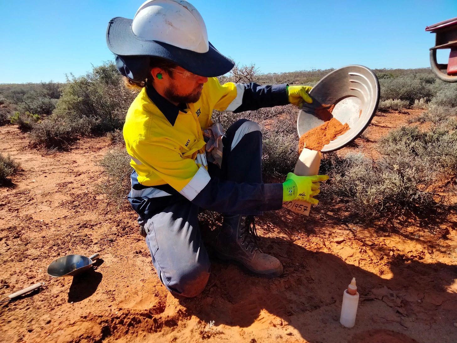 Field assistant putting soil sample into geochemical sample bags for assay at the laboratory