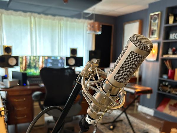 a ribbon microphone in the foreground of a recording studio