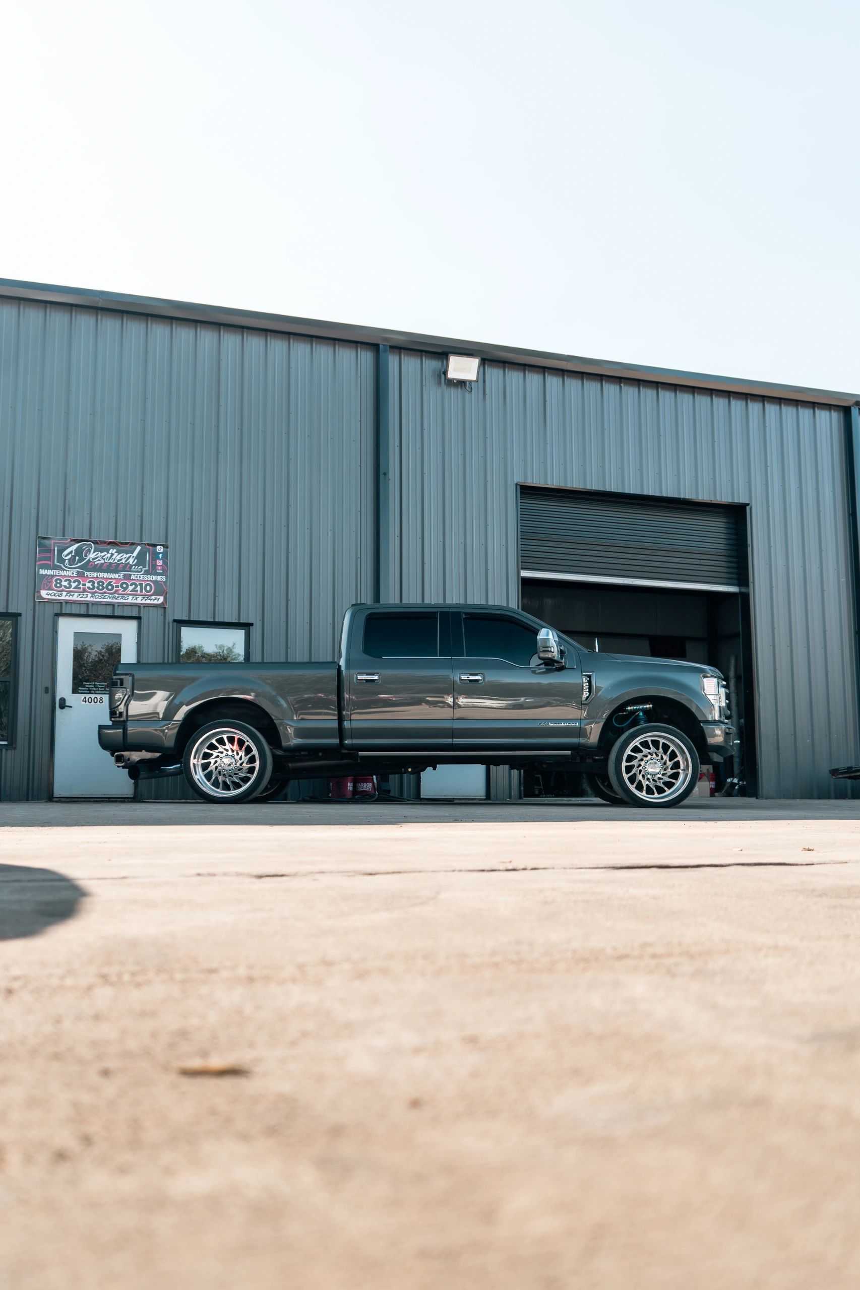 Sleek gray pickup truck parked outside a metal warehouse.
