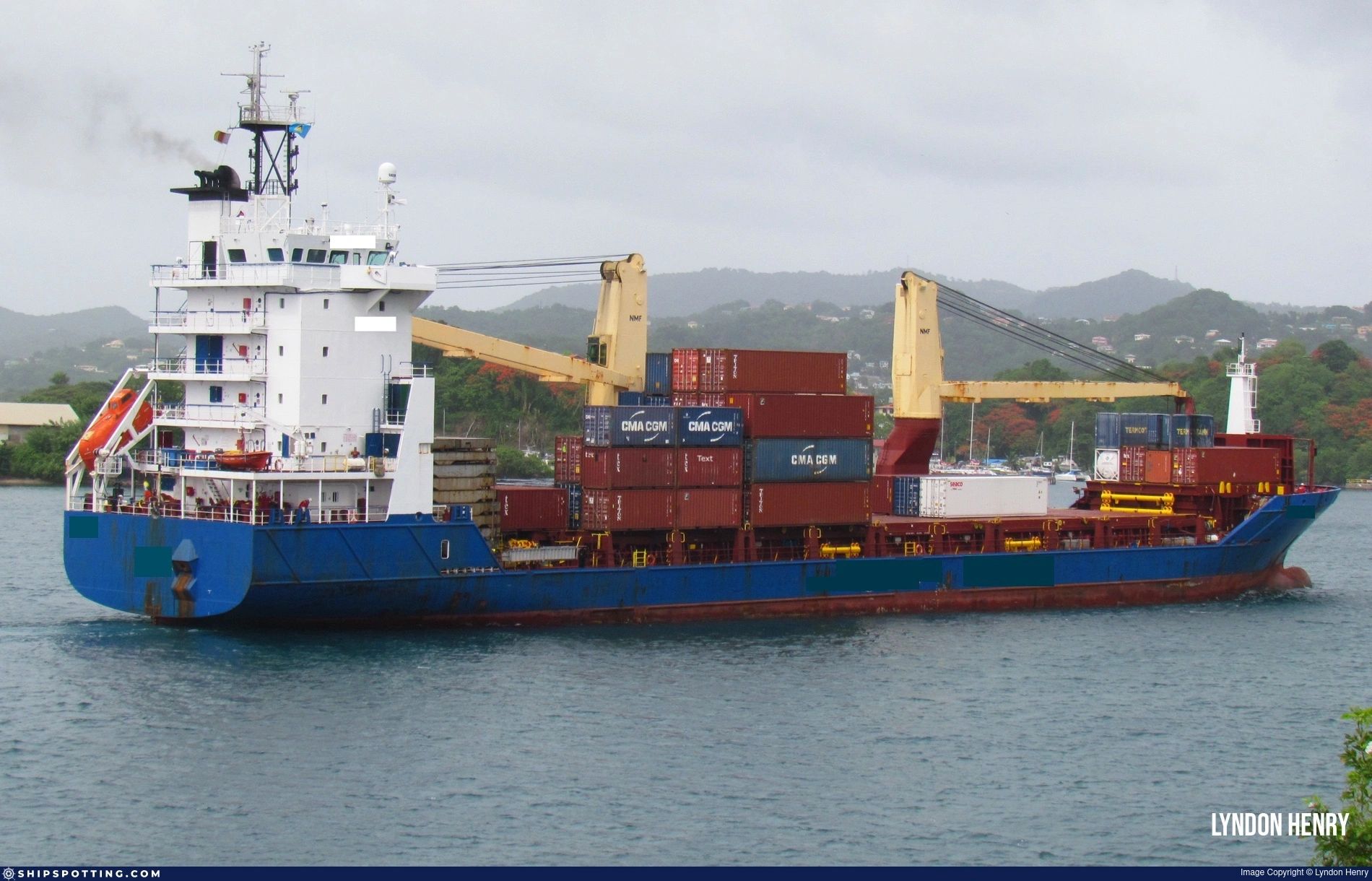 Container ship carrying stacked cargo containers on the water.