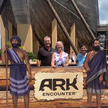 Family posing at the Ark Encounter entrance with life-sized biblical figures.