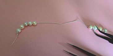 Freshwater-pearls-being-strung-on-silk-thread-with-tweezers