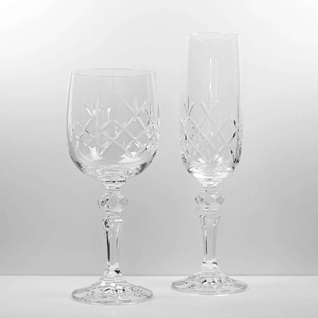 Two elegant crystal wine glasses with intricate cut patterns.