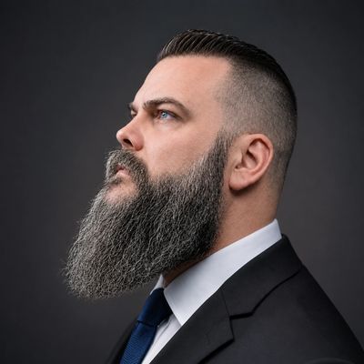 Profile of a man with a long beard and suit.