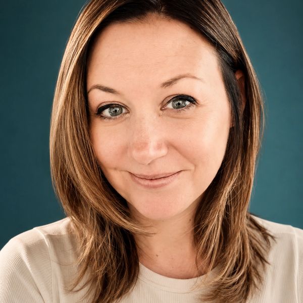 A woman smiling with a blue background.