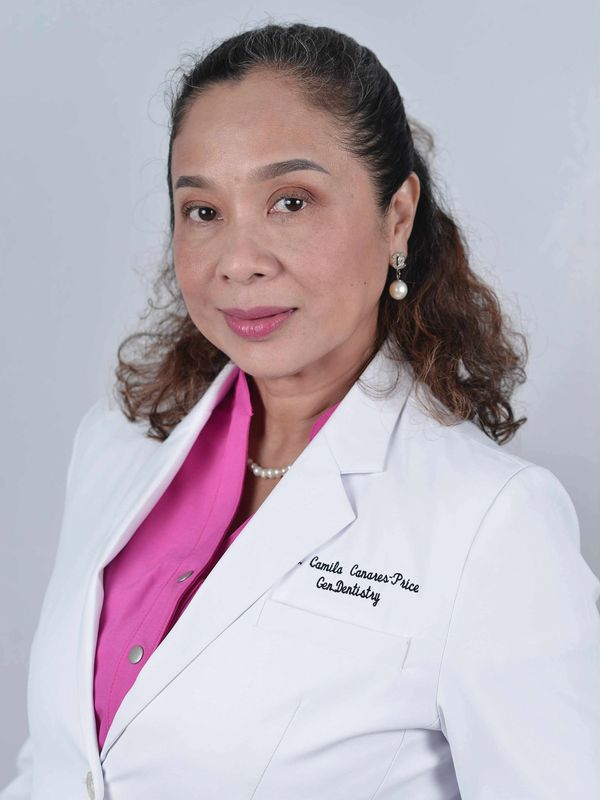 Professional woman in a white coat with pearl earrings and necklace.
