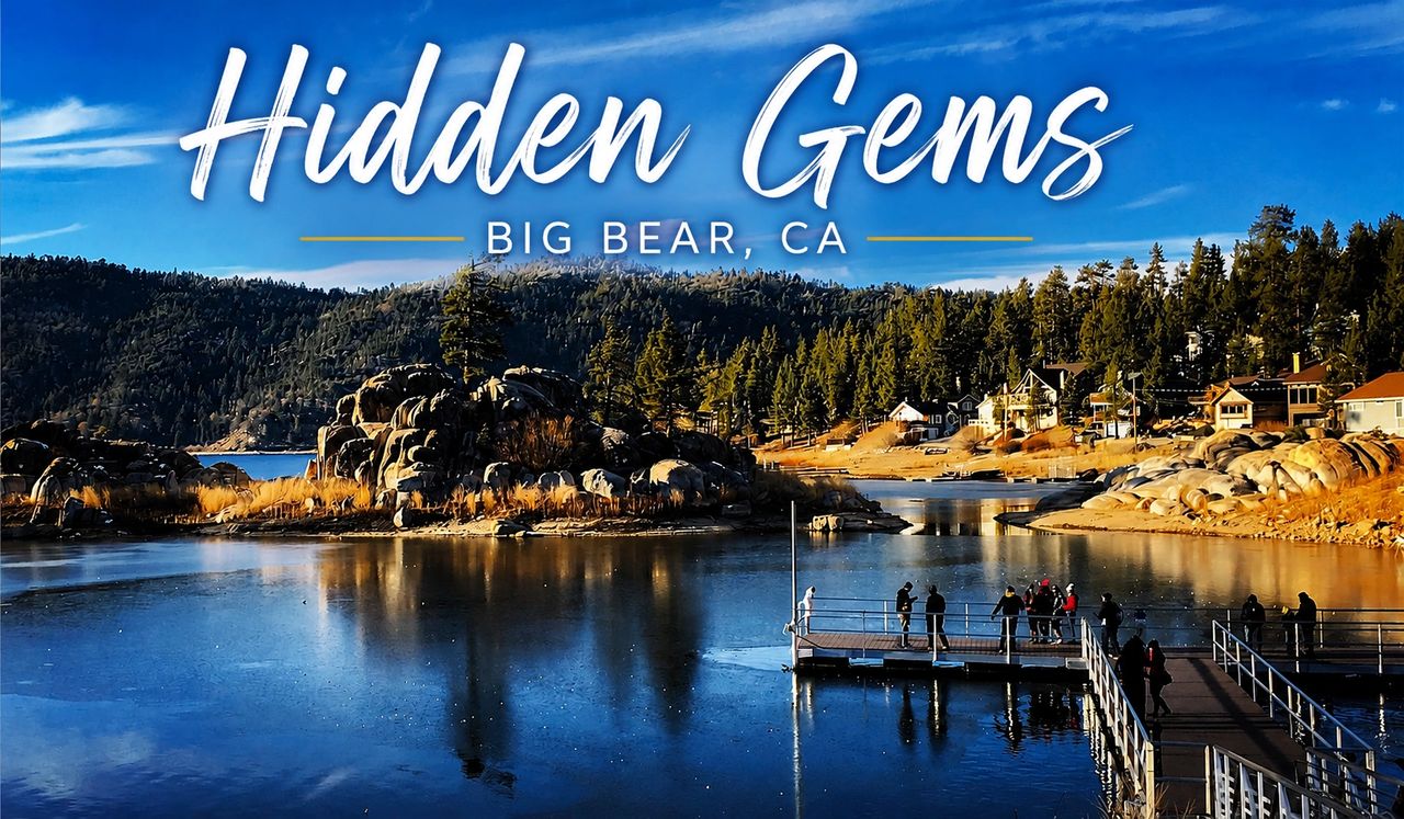 Scenic hidden gem location in Big Bear Lake, California featuring calm lake reflections, mountain forests, rocky shoreline views, and a lakeside dock beneath a bright blue sky.