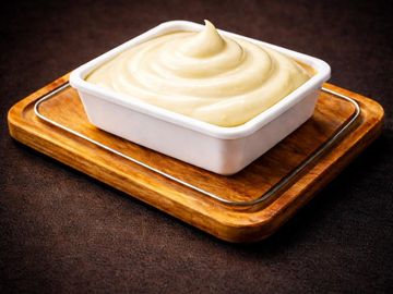 Smooth creamy dip in a white square bowl on wooden tray.