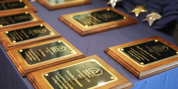 Realty award plaques displayed on a table.