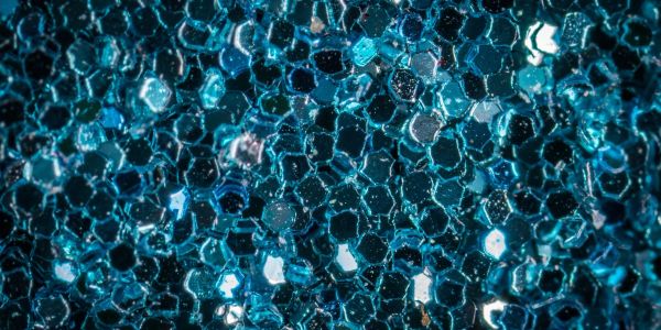 Close-up of blue hexagonal beads under light.