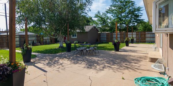 Spacious backyard with patio and greenery.