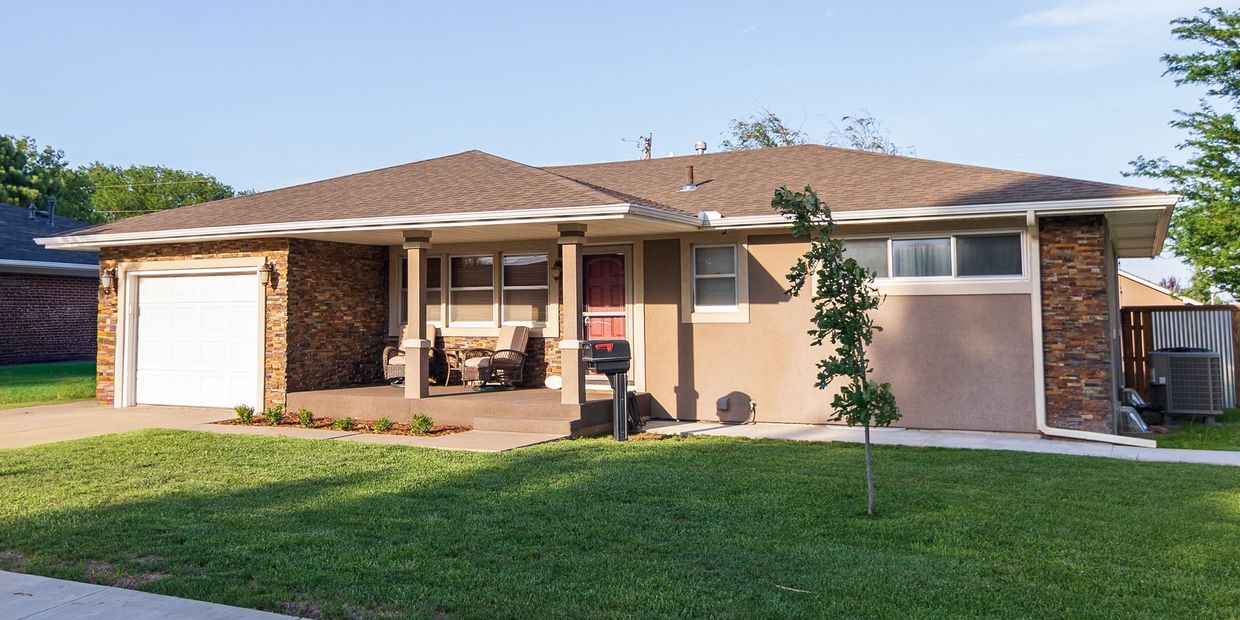 Single-story house with a front porch and lawn.