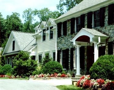 Large stone house with manicured gardens.