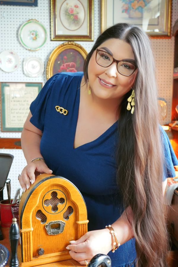 Smiling woman with long hair holding a vintage radio.