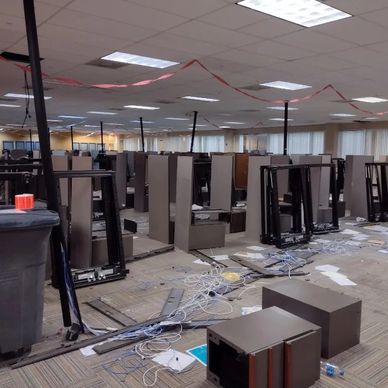A call centers office space with cubicles and filing cabinets that are being disassembled 