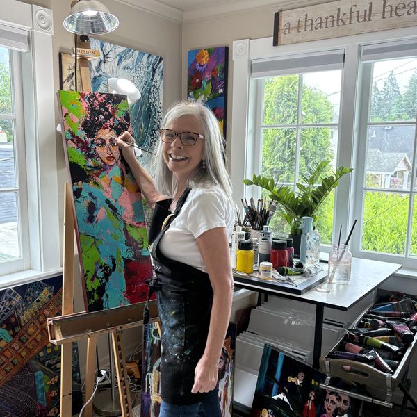Artist painting vivid abstract woman with black hair & pink, teal and bright green clothing.