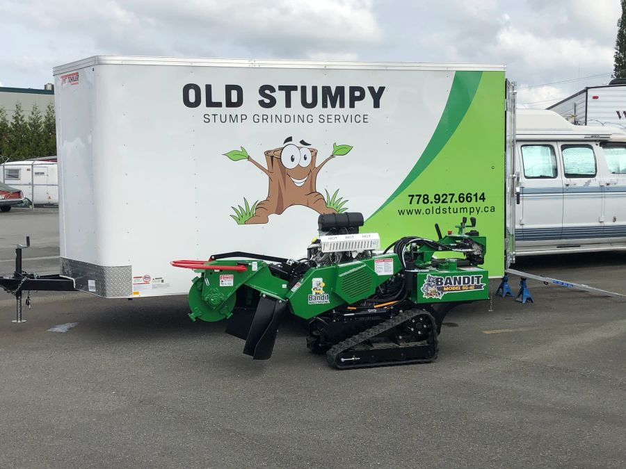 Green stump grinder in front of the Old Stumpy trailer