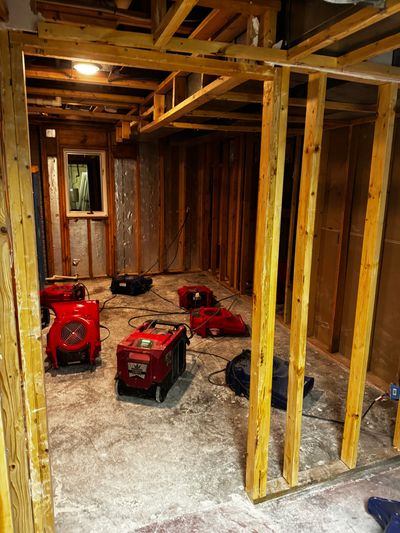 Linn Creek water mitigation: Industrial air movers and dehumidifiers drying a home's wood framing.