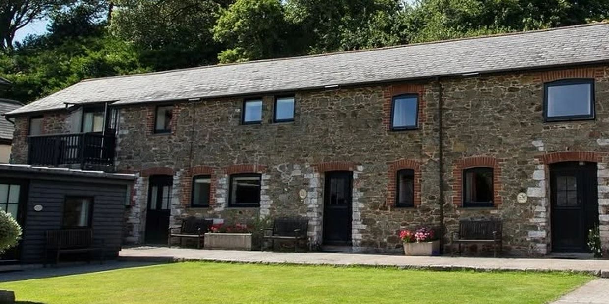 Stone house with small windows and benches outside.