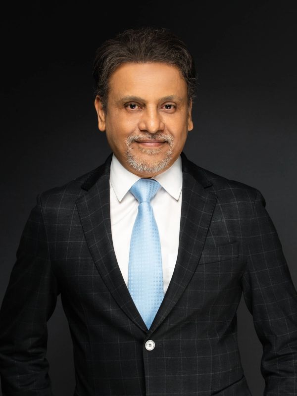 Confident man in a suit with a light blue tie.