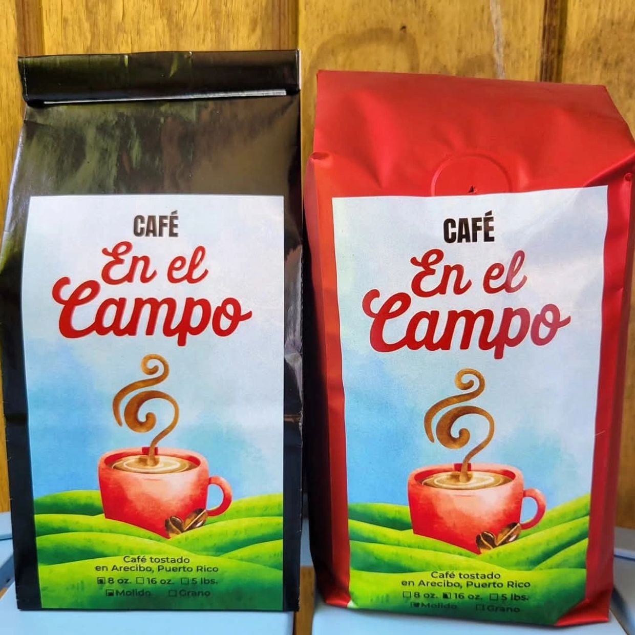 Two bags of "Café En el Campo" coffee from Arecibo, Puerto Rico, in black and red packaging.