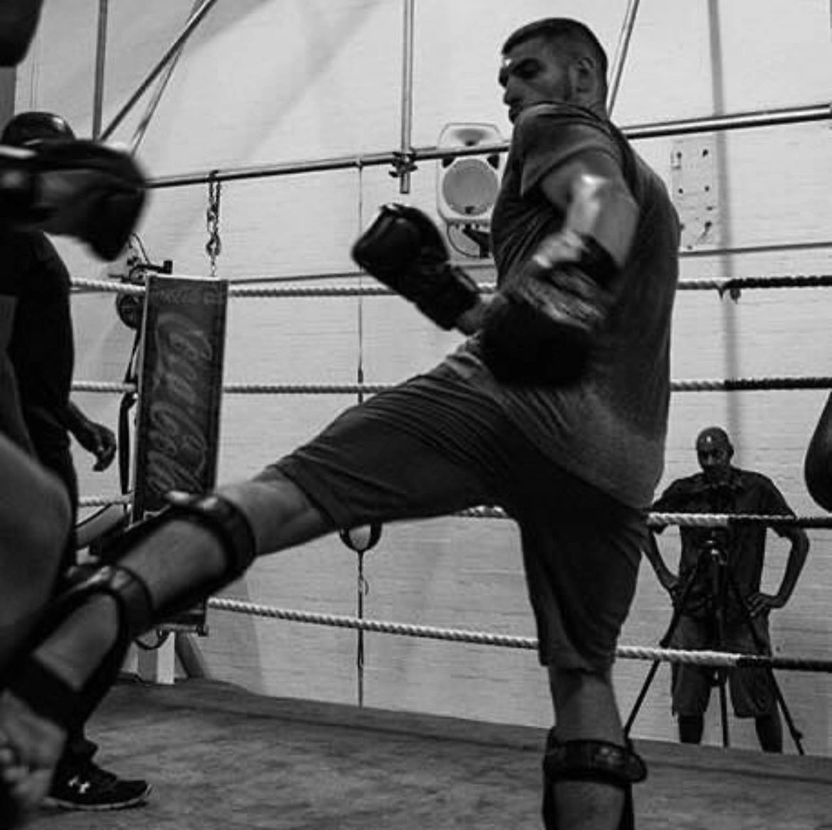 Man kicking the boxing bag.