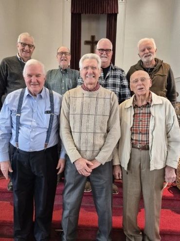 Group of elderly men posing inside a church.