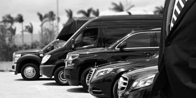 Luxury black SUVs and Maybach limousine lined up at airport runway for elite transportation service"