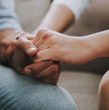 Two people holding hands, showing support and connection.