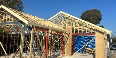 Wooden framework of a house under construction on a clear day.