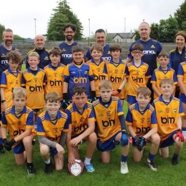 Youth sports team photo with coaches and players in yellow jerseys.