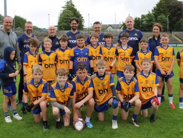 Youth sports team photo with coaches and players in yellow jerseys.