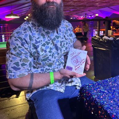 Bearded man showing an autograph with a heart.