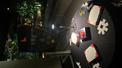 Mystical tarot reading setup with cards and candles on a dark table.