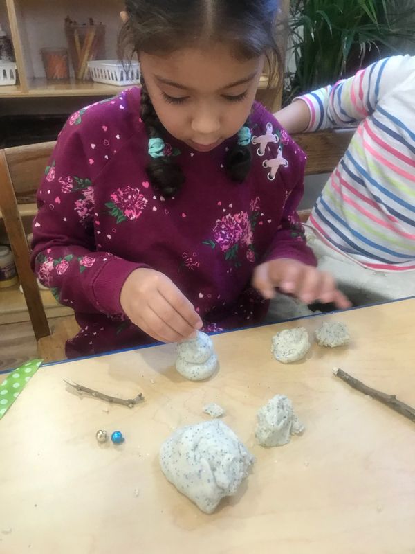 They were building snowmen with glitter playdough and natural materials.