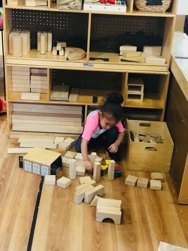 4 year old in the block area building. 
