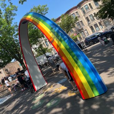 A large rainbow arch in a city park.