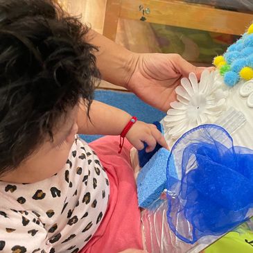An infant exploring a felt board. 