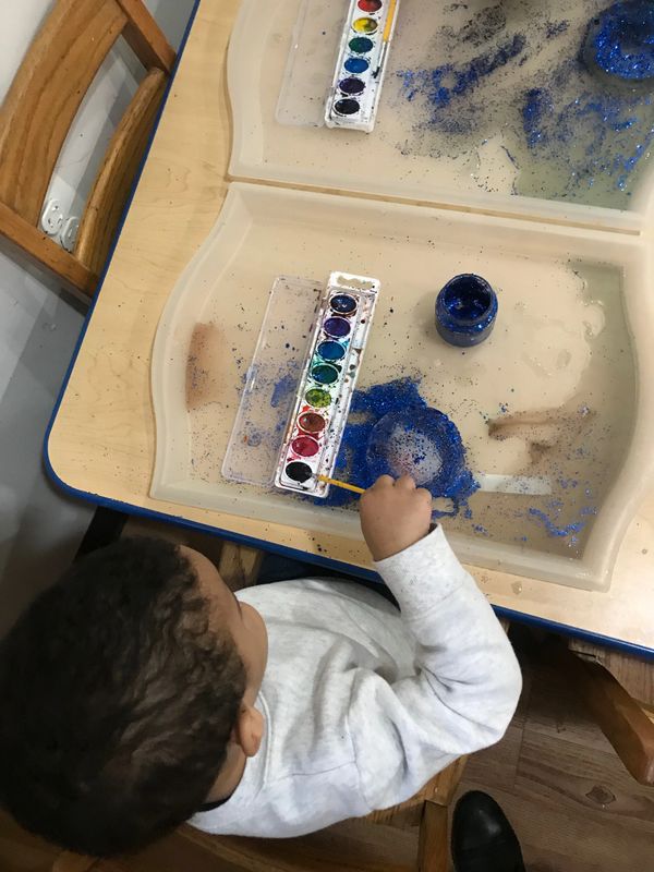 2 Year olds discovering ice  with water colors and glitter.