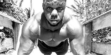 Muscular man doing push-ups outdoors.