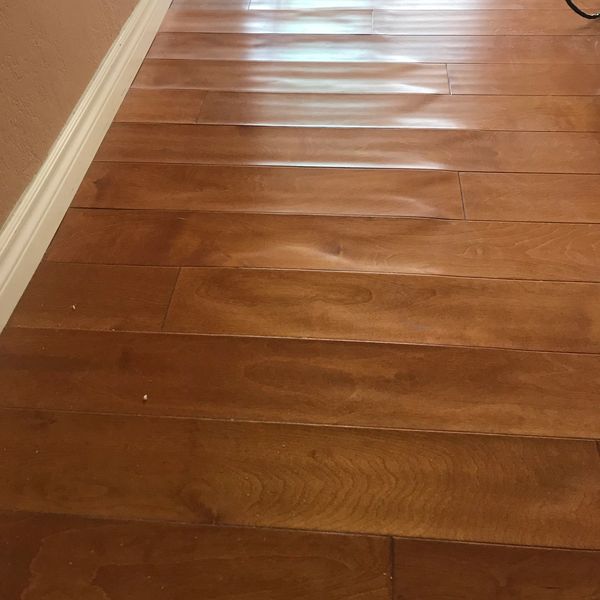 Wooden floorboards with noticeable warping and bubbling.