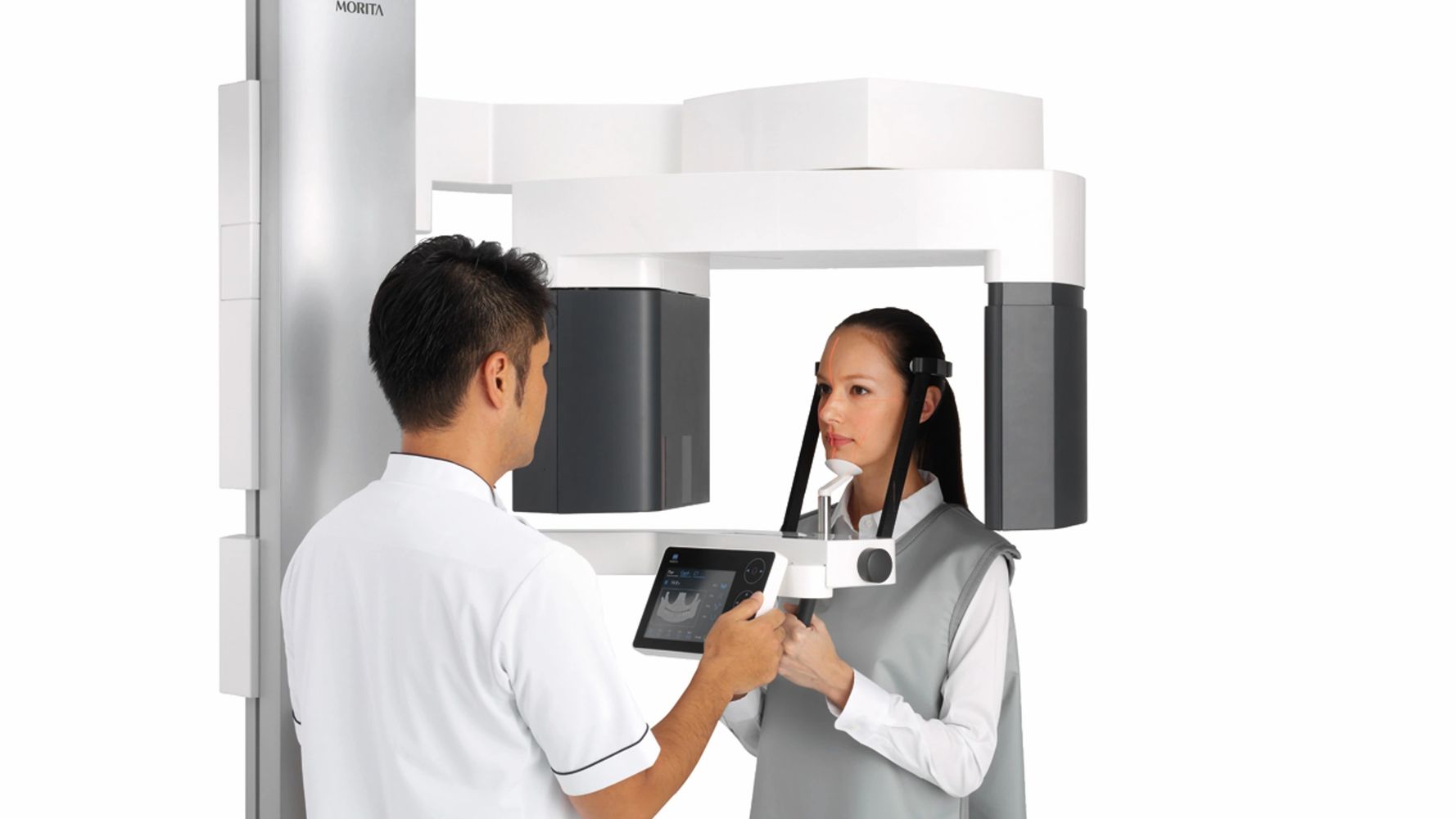 A dental professional operates a 3D dental imaging machine with a patient.