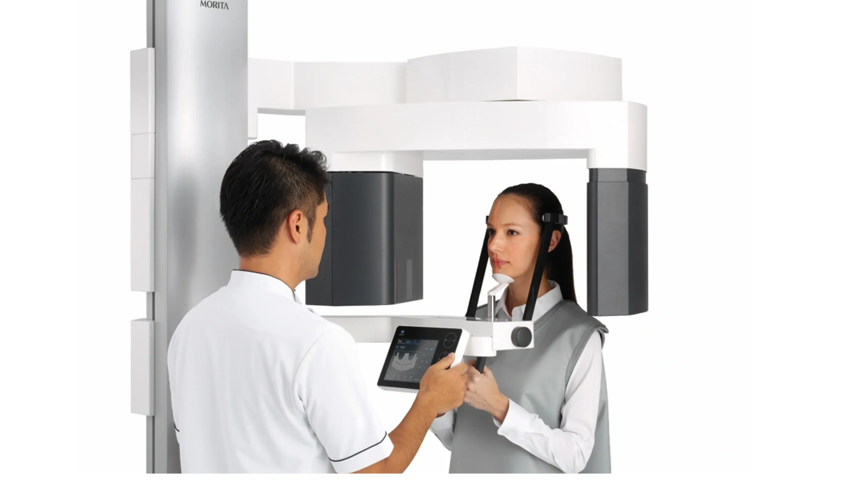 A dental professional operates a 3D dental imaging machine with a patient.