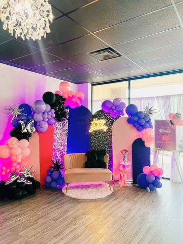 Colorful sweet 16 birthday party setup with balloons and a pink couch.