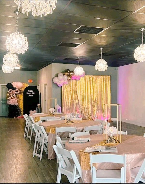 Table setup and gold shimmer panel at Suite Events venue.