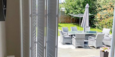 Patio doors with open tracked shutters